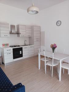 eine weiße Küche mit einem Tisch und Stühlen in der Unterkunft Mary House in Pompei