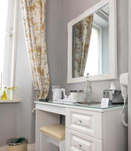 La salle de bains est pourvue d'une coiffeuse blanche et d'un miroir. dans l'établissement The Firs Bed and Breakfast, à Plymouth