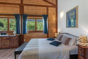 a bedroom with a large bed with blue curtains at B&B Plitvice Lakes Villa Irene in Plitvička Jezera