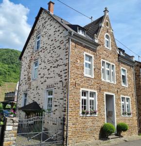 an old brick building with white windows on a street at Ferienwohnung Fritzer in Ellenz-Poltersdorf
