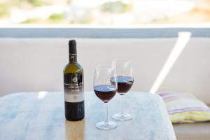 Stone house Tripiti في تريبيتي: زجاجة من النبيذ وكأسين على الطاولة