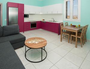 a kitchen and living room with purple cabinets and a table at Stone house Tripiti in Tripití