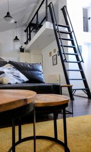 sala de estar con sofá negro y escalera en Mía Suites II Loft Centro Histórico - PARKING & WIFI FREE, en Burgos