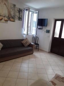 ein Wohnzimmer mit einem Sofa und einem TV in der Unterkunft Case vacanze Vignola in Peschici