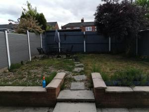 einen Hinterhof mit einem Garten mit einem Zaun und einem Garten sidx sidx sidx in der Unterkunft Hinchley House - Your Manchester Haven in Manchester