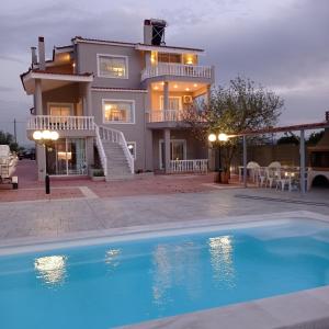 a house with a swimming pool in front of a house at Villa Costa in Periyiálion