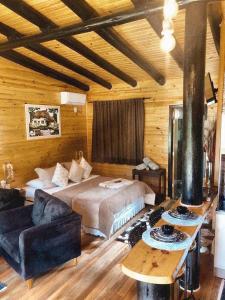 a bedroom with a bed and a couch in a room at Cabanas Capoeiras in Urubici
