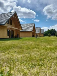 two houses in a field with a bike in front at Domki Rózin in Zwierzyniec