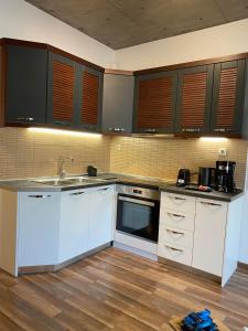 a kitchen with white cabinets and a sink at The Grey Apartments in Volos