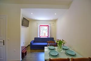 a living room with a table and a blue couch at Douskos Porta Rossa in Hydra