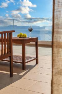 a table with a glass of wine on a balcony at Porto Kaza in Sitia