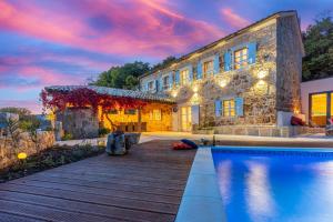 a house with a swimming pool next to a building at Villa Bell Aria in Grižane