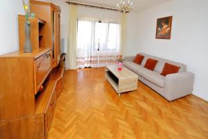 ein Wohnzimmer mit einem Sofa und einem TV in der Unterkunft Apartmani Bruno in Bibinje