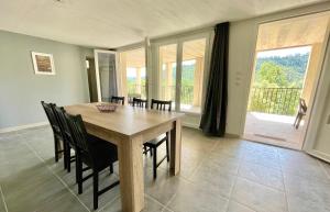 a dining room with a wooden table and chairs at Belle vue des Cévennes in Corbés