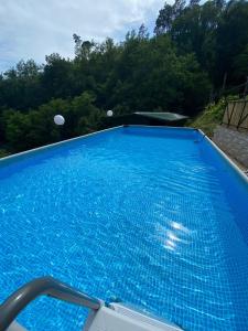 una gran piscina azul con árboles en el fondo en Villa Maremonti - con 3 piscine, en Sestri Levante