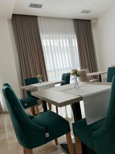 a dining room with a table and green chairs at Majestic Boutique Hotel ADULT ONLY in Baile Felix
