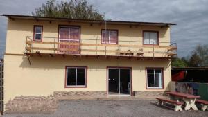 a yellow house with a balcony on top of it at La Baquiana in Mercedes