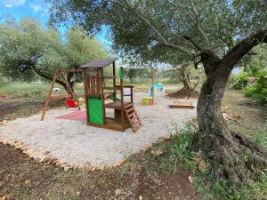 a playground with a tree and a swing at Paraiso Bell Tent in Tortosa