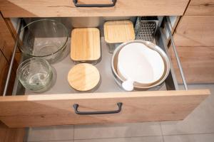a drawer with bowls and other items in a kitchen at Ferienwohnung heimatselig Wolframs-Eschenbach in Wolframs-Eschenbach