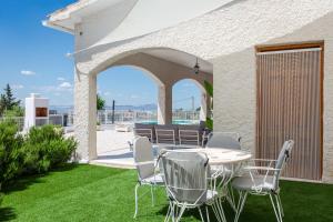 a patio with a table and chairs on the grass at Imperial Malibu by Fidalsa in Crevillente