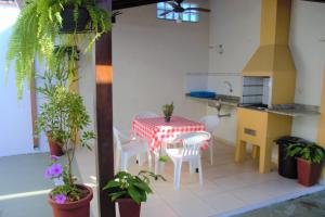 a kitchen with a table and chairs and plants at Marujo Hostel in Ubatuba