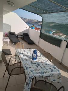 a table and chairs on a balcony with a view of the ocean at Apartments "Sun-sea" in Rab