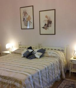 a bedroom with a bed with two pictures on the wall at La Corte del Barbio in Aramengo