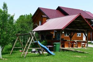 a playground with a slide and a house at Apartments Laura in Rakovica