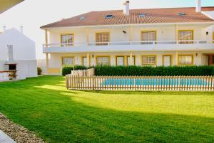 uma casa com uma cerca em frente a um quintal em Carlos House - Baleal beach, Sunny balcony, Shared pool no Baleal