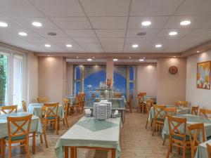 ein Restaurant mit Tischen und Stühlen in einem Raum in der Unterkunft Hotel Touring in Nagykanizsa