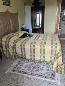 a bedroom with a large bed with a checked comforter at La Corte del Barbio in Aramengo