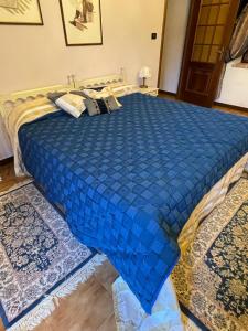 a bed with a blue comforter in a bedroom at La Corte del Barbio in Aramengo
