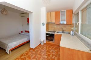 a kitchen with a sink and a bed in a room at Apartmani Bruno in Bibinje