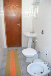 a bathroom with a toilet and a sink and a door at Marujo Hostel in Ubatuba