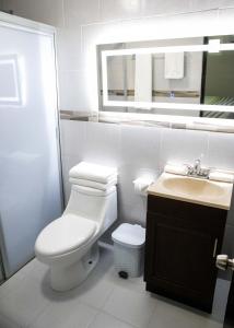 y baño con aseo, lavabo y espejo. en Donjuan By Melida Hotel en Cabo San Lucas