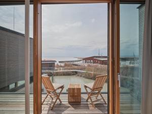 two chairs on a balcony with a view of the ocean at Exklusives Ferienhaus - Direkt am Neusiedler See in Neusiedl am See