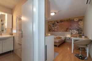 a bathroom with a sink and a bedroom with a bed at Apartments Leonarda in Trogir