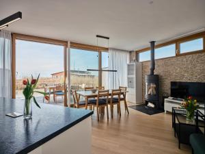 a kitchen and living room with a table and a fireplace at Exklusives Ferienhaus - Direkt am Neusiedler See in Neusiedl am See