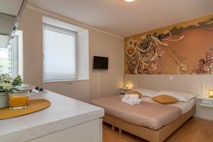 a small bedroom with a bed and a kitchen at Apartments Leonarda in Trogir
