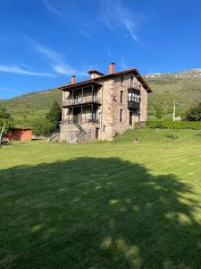 an old brick house on a grassy field at El Molino de Cicera in Cicera