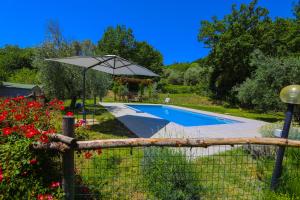 una valla con sombrilla junto a la piscina en B&B COLdiFIORE, en Penna in Teverina