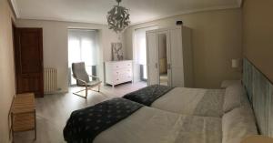 1 dormitorio con cama, silla y vestidor en Apartamento Estiviellas, Pirineo, en Jaca