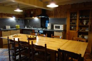 una cocina con una gran mesa de madera y sillas en Le Mas Balmat en Ayguatebia