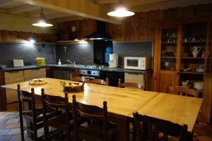 a kitchen with a large wooden table and chairs at Le Mas Balmat in Ayguatebia
