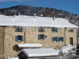 a stone building with snow on the roof at Le Mas Balmat in Ayguatebia