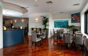 a restaurant with a table and chairs and a bar at Schull Harbour Hotel & Leisure Centre in Schull