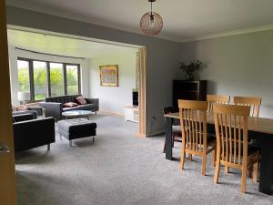 uma sala de estar com uma mesa e um sofá em Lyn leven cottages em Ballachulish
