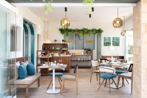 un restaurant avec des tables et des chaises et une cuisine dans l'établissement ELLE Rooms & Suites, à Paralia Katerinis