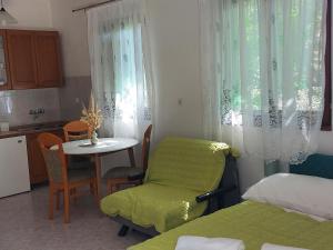 Cette petite chambre comprend une table et une chaise verte. dans l'établissement Studio Klara, à Draga Bašćanska