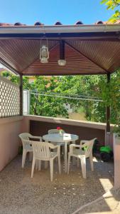 d'une terrasse avec une table et des chaises sous un auvent. dans l'établissement Studio Klara, à Draga Bašćanska